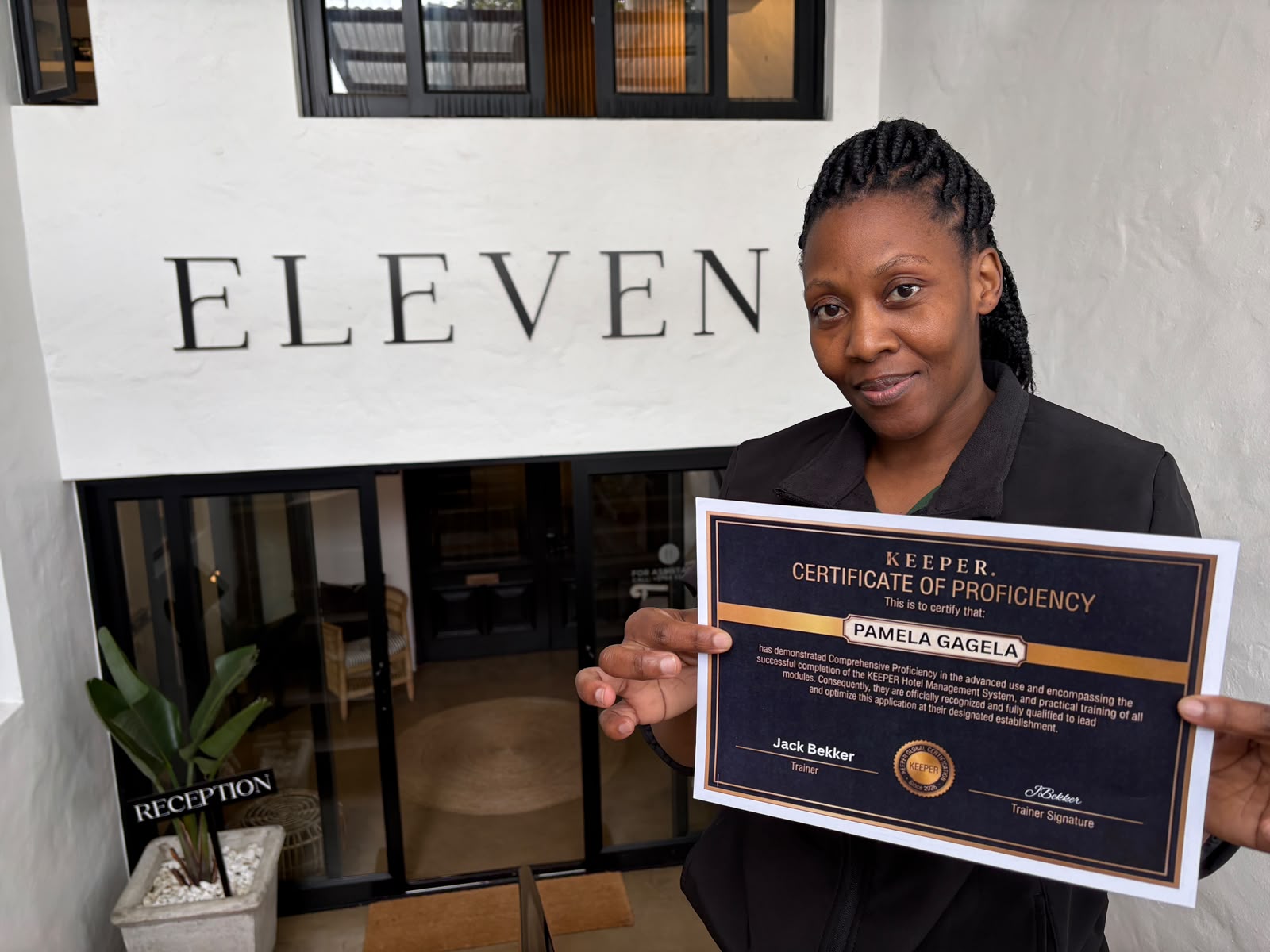 Pamela Gagela holding her Host Certificate of Proficiency outside Eleven Hotel