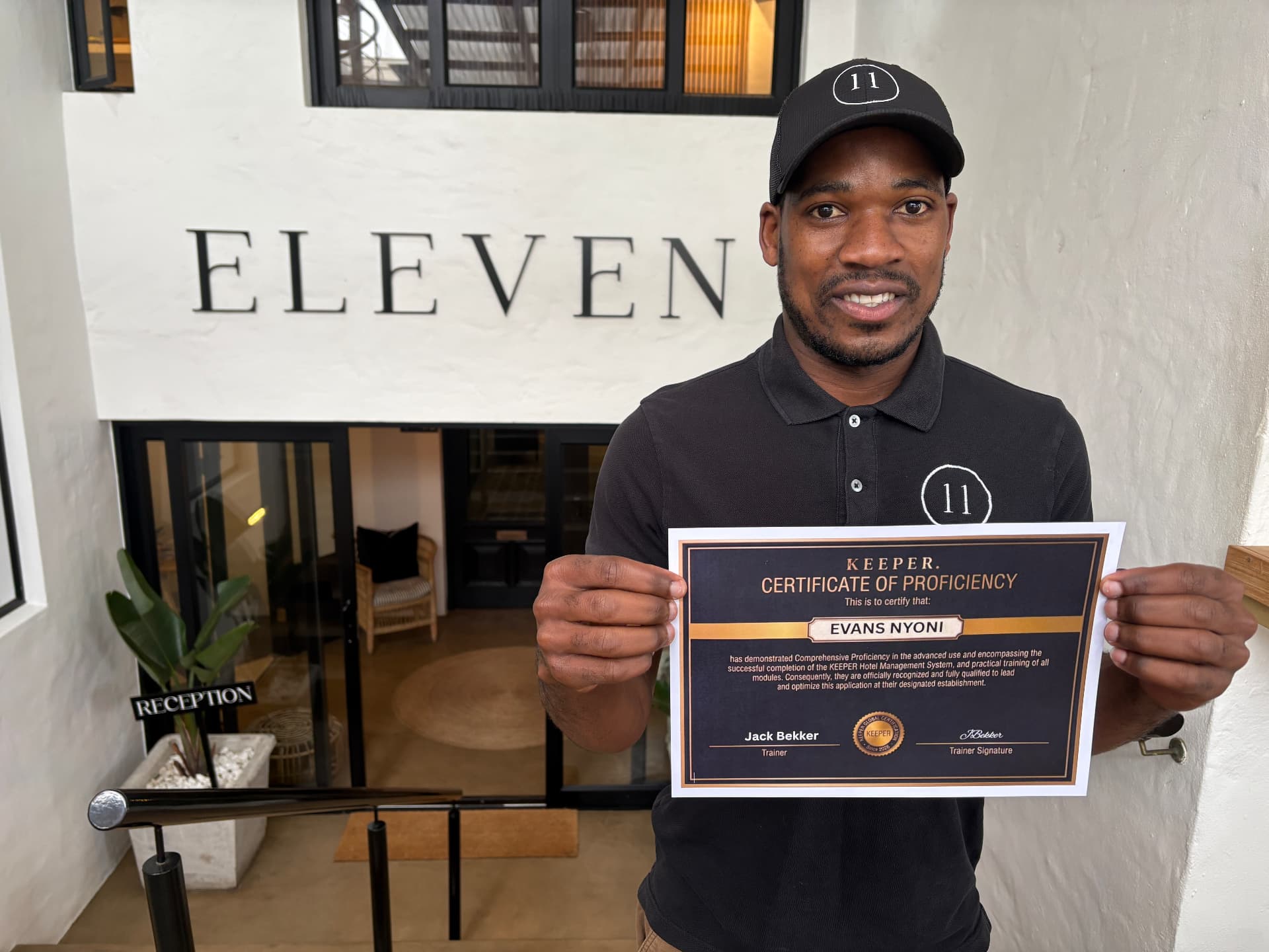 Evans Nyoni holding his Host Certificate of Proficiency outside Eleven Hotel